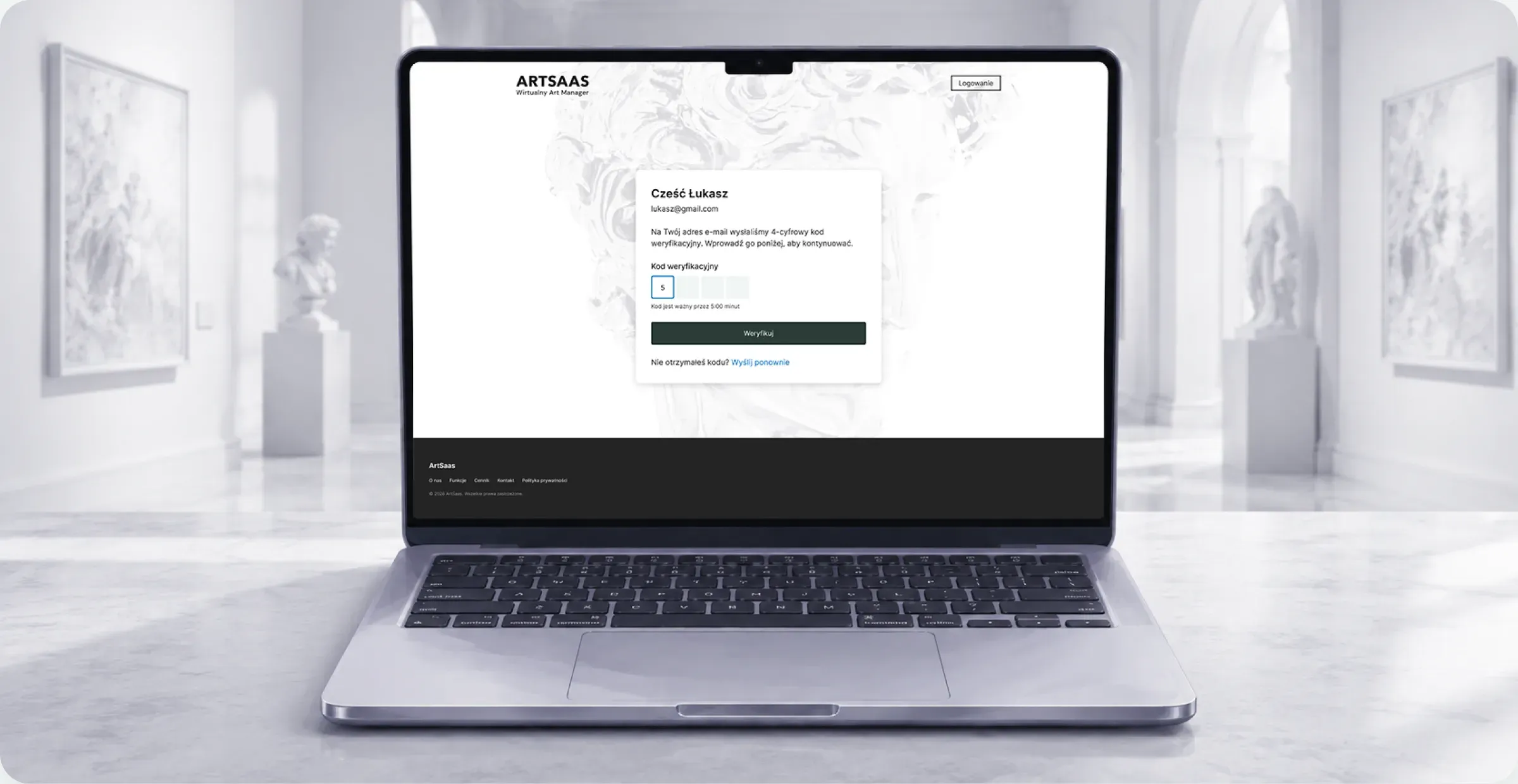 Laptop na marmurowym blacie w białej galerii rzeźb. Na ekranie strona logowania ArtSaas z polem na kod weryfikacyjny.